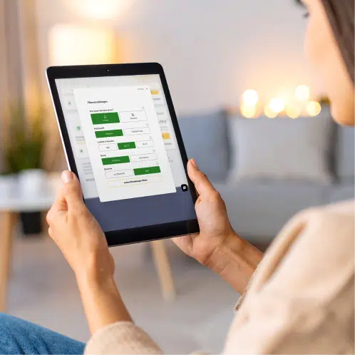 Kostenlos-personlich-unabhangig Eine Frau sucht selbst einen neuen Stromanbieter, indem sie zu Hause auf ihrem Tablet sitzt.