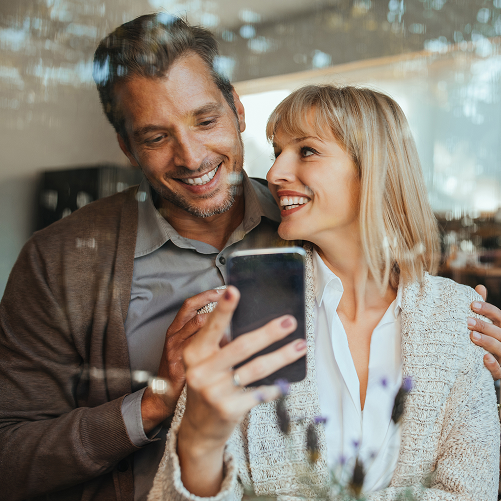 flexiblestromtarife1 fröhliches Paar vergleicht Tarife auf dem Handy